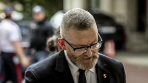 Grzegorz Braun opuszczający Sejm po zniszczeniu wystawy