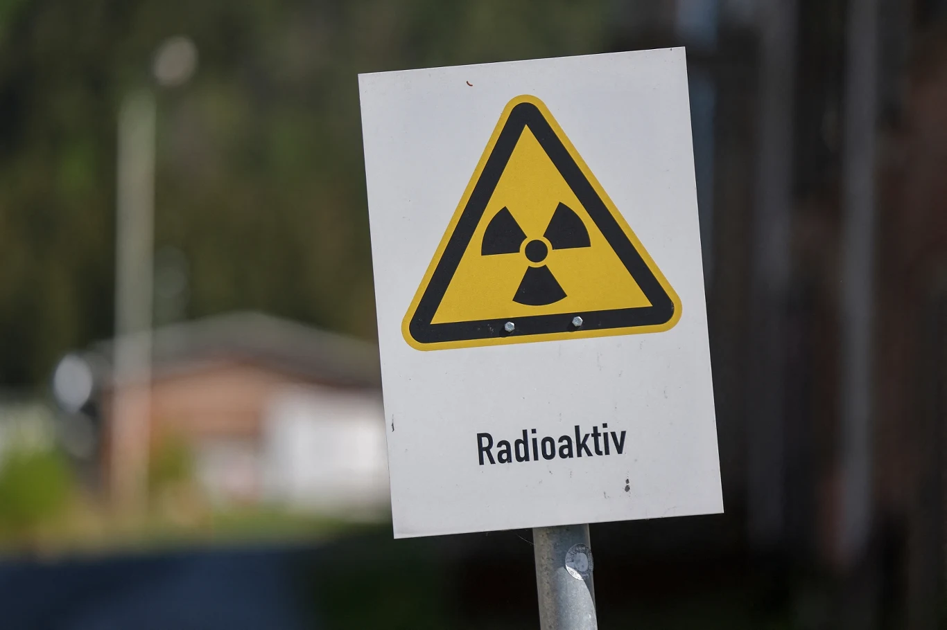 Ruda uranu po obróbce przemienia się w tzw. yellowcake, czyli oczyszczone tlenki uranu, W nich 0.7 proc. składu stanowi izotop U-235. Aby użyć uranu w celach wojskowych izotop U-235 musi obejmować od 90 proc. składu wzwyż Tablica ostrzegawcza z symbolem promieniowania jonizującego oraz napisem 'Radioaktiv', umieszczona na tle rozmytego budynku.