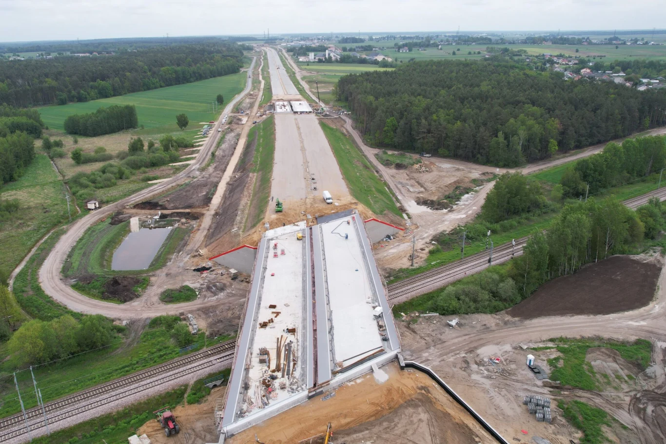 Całkowity koszt realizacji tego odcinka autostrady A2 wynosi ponad 2,9 mld. Budowa nowoczesnej drogi oraz mostu nad linią kolejową, otoczona zielonymi polami oraz lasem, widok z lotu ptaka pozwala zobaczyć postęp prac budowlanych i rozległość inwestycji.