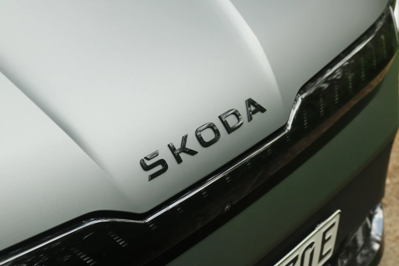 Pas świetlny "Light Band" jest w modelu RS dostępny w standardzie Logo marki Škoda umieszczone na masce samochodu w kolorze matowym, fragment przedniej części auta z widoczną osłoną chłodnicy i fragmentem tablicy rejestracyjnej.