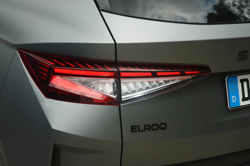 Elroq RS w standardzie oferuje także tylne światła LED z dynamicznymi kierunkowskazami. Zbliżenie na tylną lampę samochodu marki Škoda Elroq z widocznym nowoczesnym wzorem świateł oraz fragmentem numeru rejestracyjnego.