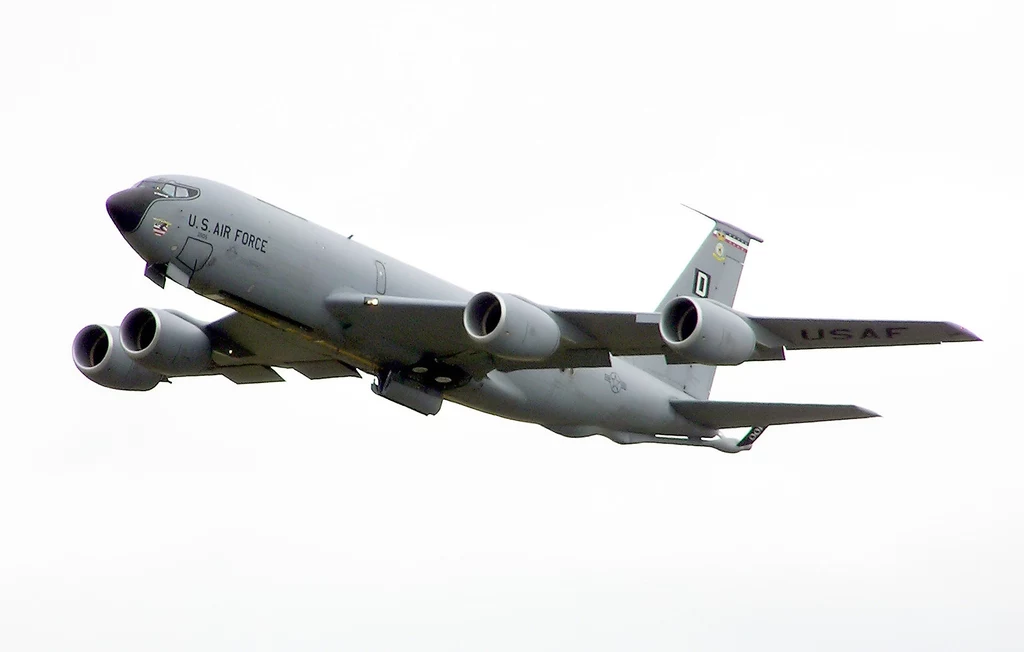 KC-135 Stratotanker jest najpowszechniejszym tankowcem powietrznym lotnictwa bojowego USA Wojskowy samolot transportowy sił powietrznych USA z charakterystycznym szarym malowaniem i czterema silnikami odrzutowymi wznosi się na tle jasnego, bezchmurnego nieba.