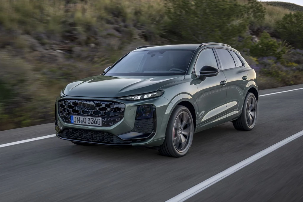 Niemcy zajęli się również aerodynamiką modelu. Współczynnik oporu powietrza w nowym Audi Q3 wynosi 0,30. Jadący po asfaltowej drodze nowy SUV Audi Q5 w kolorze zielonym, po bokach widoczne zarośla i drzewa, w tle niewielkie wzniesienia, scena uchwycona w ruchu na otwartej przestrzeni.