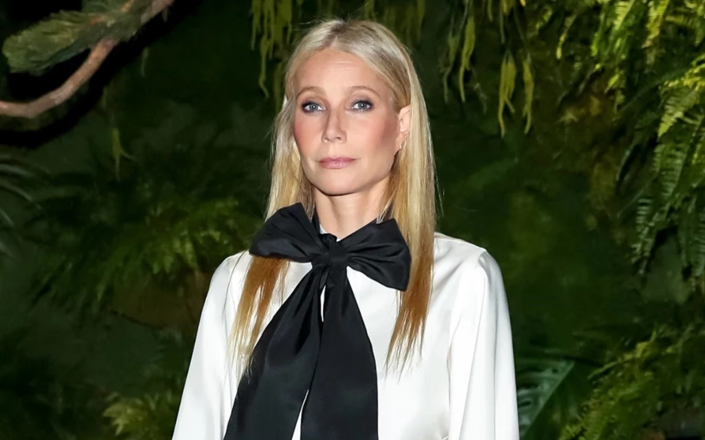 Gwyneth Paltrow z dużą, czarną kokardą do białej koszuli