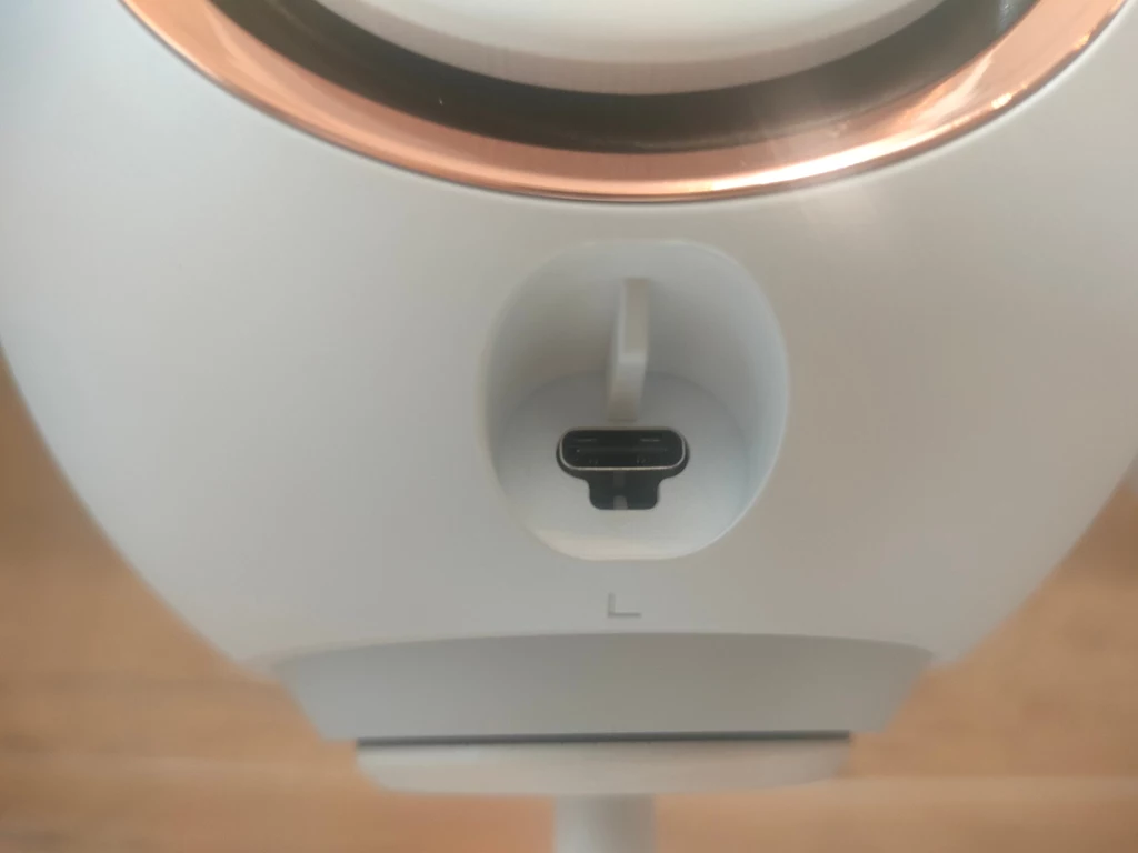 Creative Pebble Nova Zbliżenie na port USB-C umiejscowiony w dolnej części urządzenia elektronicznego o opływowych kształtach z białą i złotą obwódką.