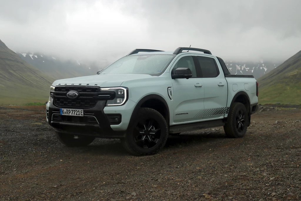 Najdroższy w polskiej ofercie jest wariant Stormtrak. Jasnoszary pickup marki Ford w terenie górskim, otoczony mgłą i niskimi chmurami, stoi na nierównym, żwirowym podłożu, w tle widoczne strome zbocza pokryte resztkami śniegu.