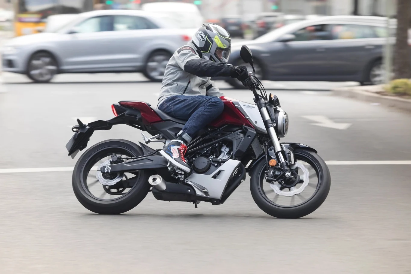 Prawo jazdy kategorii B pozwala na jazdę motocyklami z silnikami większymi niż 125 ccm, ale są warunki Motocyklista w kasku i ochronnej odzieży jedzie nowoczesnym czarnym motocyklem po ulicy miejskiej, w tle widoczne rozmazane samochody.