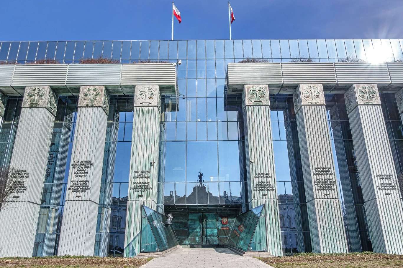Sąd Najwyższy uznał trzy protesty wyborcze za zasadne Nowoczesny budynek z dużymi szklanymi powierzchniami na fasadzie, wysokie kolumny ozdobione emblematami prawniczymi, wejście do obiektu znajduje się pośrodku, na szczycie budynku powiewają dwie flagi Polski.