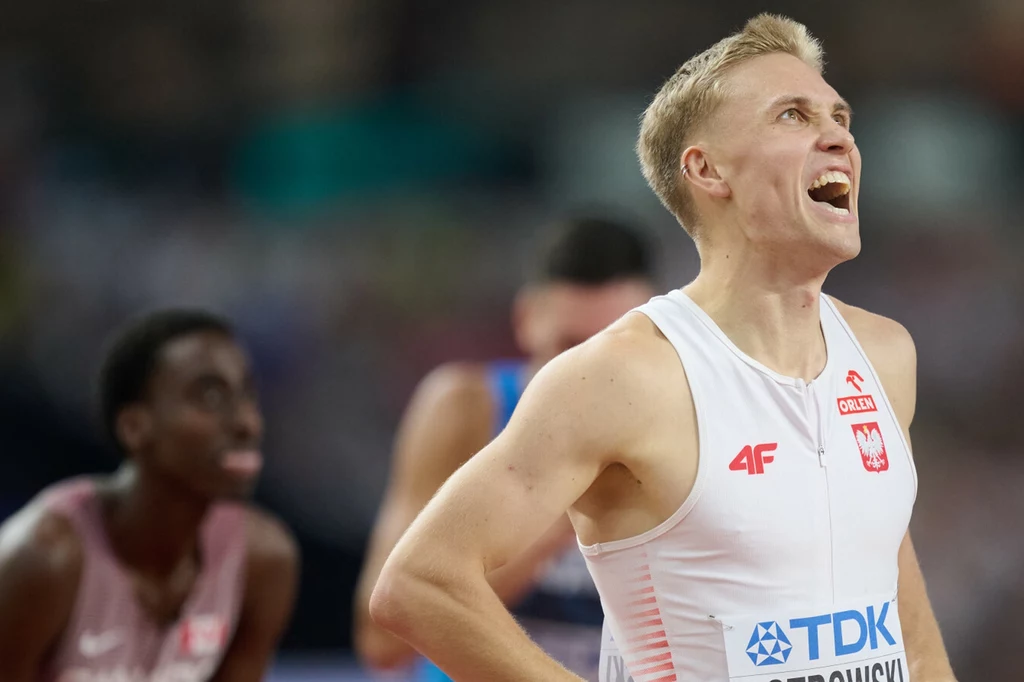 Filip Ostrowski pobił rekord życiowy w Ostrawie. A finiszujący za nim Patryk Sieradzki... uczynił to samo Lekkoatleta w białym stroju reprezentacji Polski podczas zawodów sportowych, z wyrazem radości na twarzy, w tle inni sportowcy na bieżni.