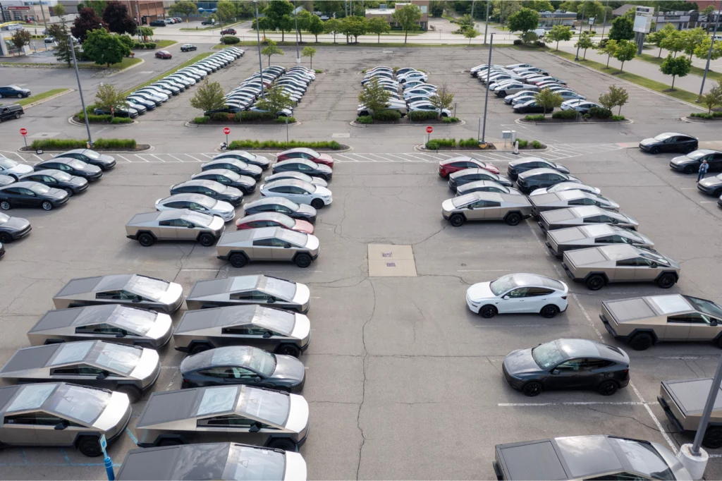 Finalnie wszystkie samochody Tesli zostały usunięte z parkingu. Pracownicy mówili, że znalazły nowych nabywców i niebawem zostaną dostarczone do klientów. Duży parking zapełniony identycznymi, futurystycznymi samochodami elektrycznymi Tesla Cybertruck, zaparkowanymi w równych rzędach, na tle niewielkiej liczby zieleni i pustych miejsc w tle.