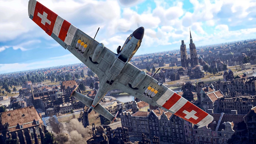 C-3604 Samolot wojskowy z wyraźnymi oznaczeniami czerwonych krzyży na skrzydłach przelatuje nad miastem z historyczną zabudową i katedrą na horyzoncie.
