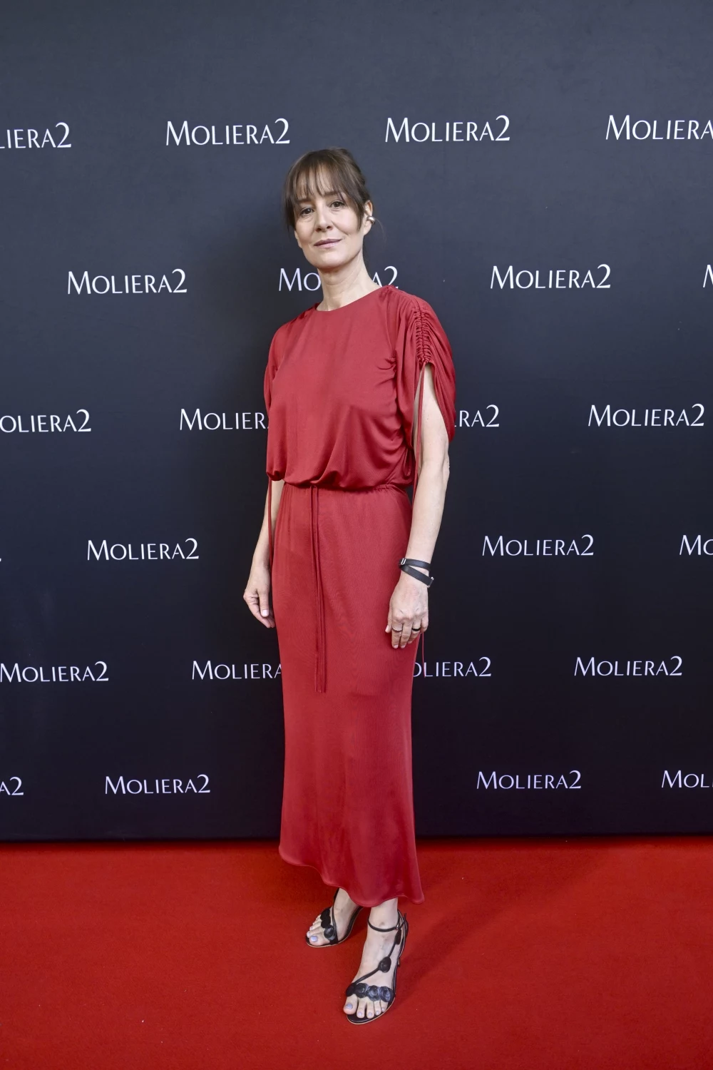 Maja Ostaszewska postawiła na elegancką prostotę Maja Ostaszewska w czerwonej, eleganckiej sukni i czarnych sandałach pozuje na czerwonym dywanie przed ścianką z logo Moliera2.