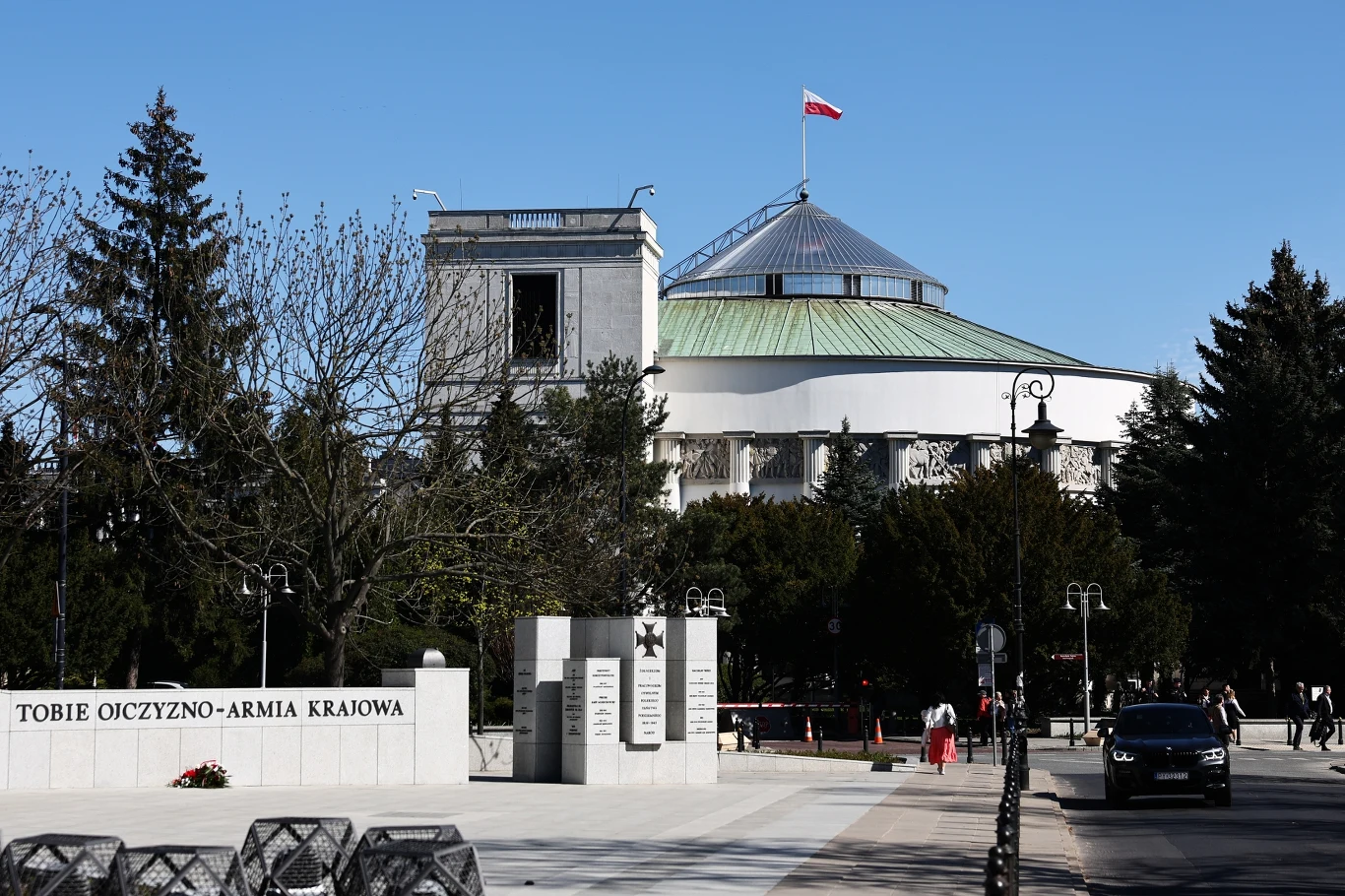 W polityce nic nie jest dane raz na zawsze Budynek polskiego Sejmu z widoczną kopułą oraz maszt z powiewającą flagą Polski, na pierwszym planie pomnik Armii Krajowej z napisem 'Tobie Ojczyzno-Armia Krajowa' otoczony przez drzewa oraz szeroki plac miejskiego ruchu pieszego i samochodowego.