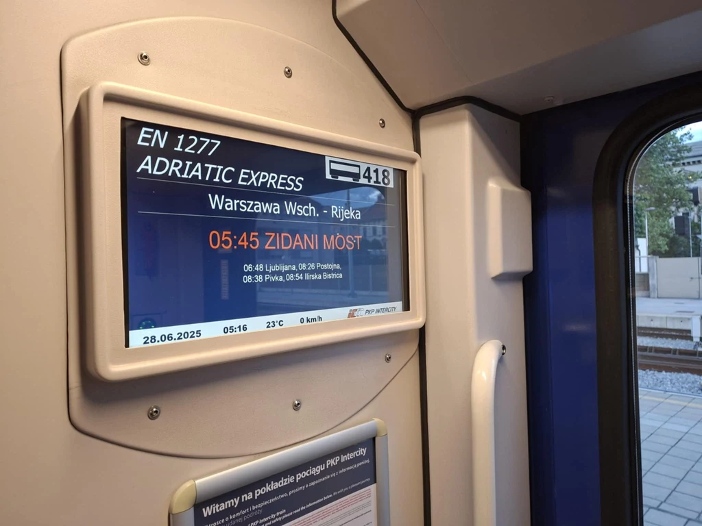 Tablica z kolejnymi stacjami w "Adriatic Expressie" Elektroniczny wyświetlacz wewnątrz pociągu pokazujący szczegóły trasy Adriatic Express z Warszawy Wschodniej do Rijeki, z wyszczególnionymi godzinami i przystankami pośrednimi, datą oraz aktualną temperaturą powietrza.