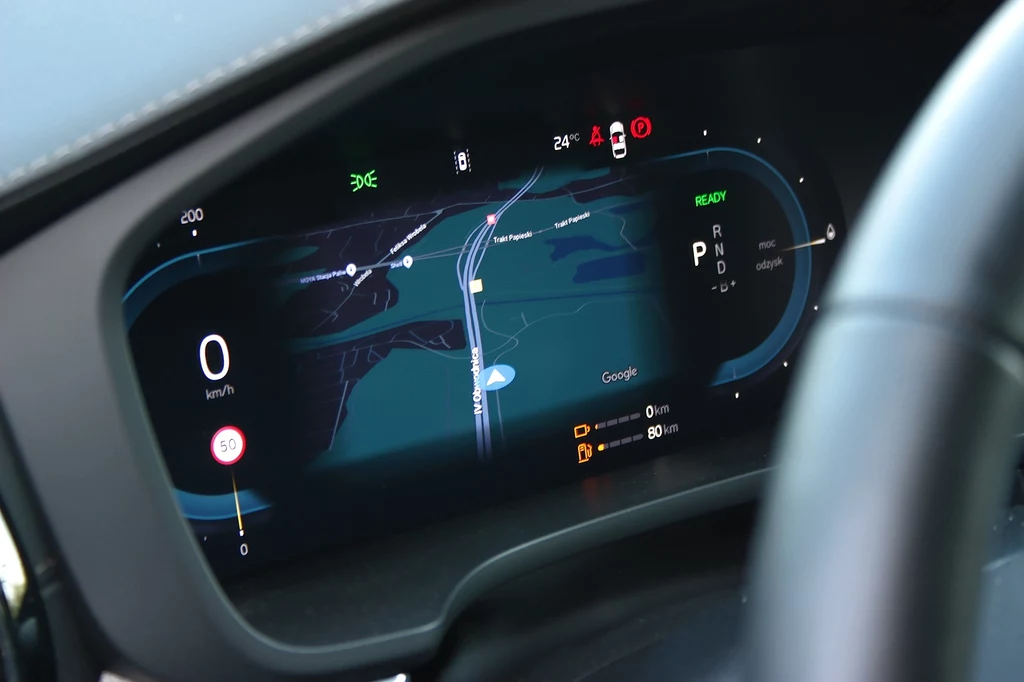 Na ekranie między zegarami można wyświetlić mapę albo nie. I to cała personalizacja Nowoczesny wyświetlacz elektroniczny w samochodzie prezentuje cyfrowe prędkościomierze, aktualne informacje o stanie pojazdu oraz szczegółową mapę nawigacji Google, otoczony eleganckim wnętrzem auta.