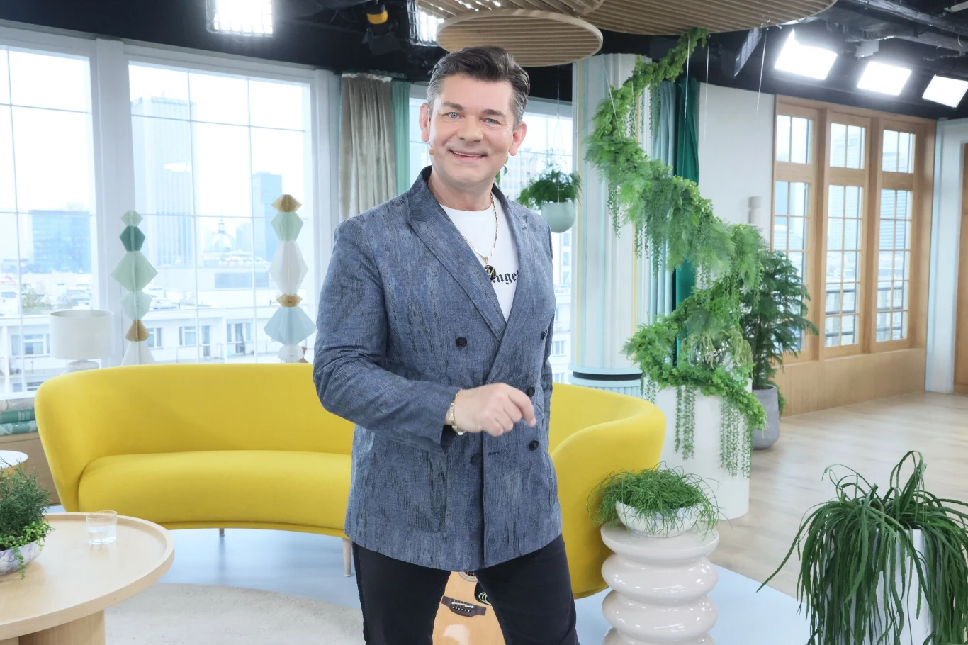 Zenek Martyniuk nagrał piosenkę "Mandacik" z grupą Łobuzy Mężczyzna w eleganckiej marynarce stoi w nowoczesnym, jasnym pomieszczeniu na tle żółtej sofy oraz licznych roślin doniczkowych, za nim duże okna wpuszczają dużo światła dziennego.