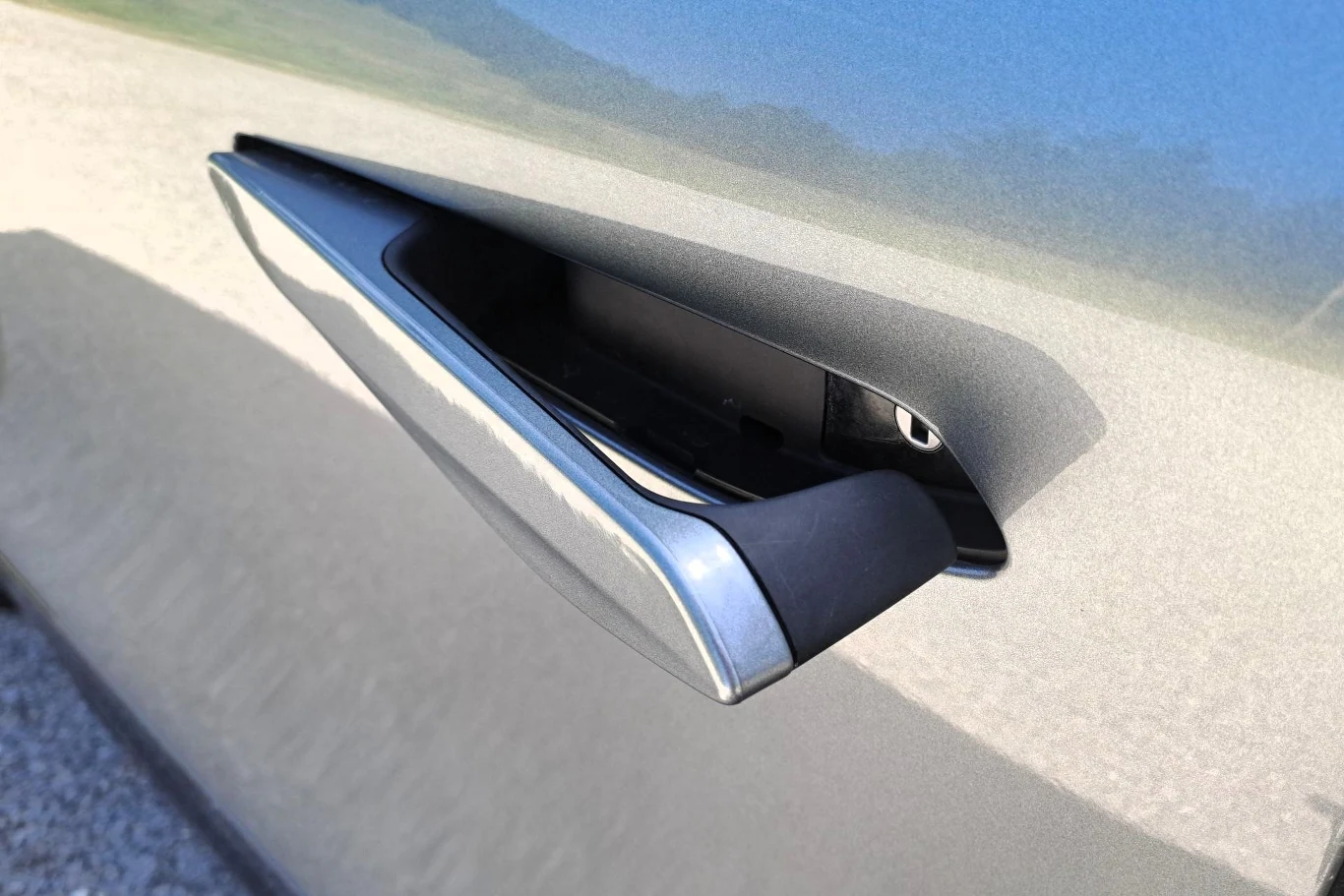 metaliczna, wysuwana klamka samochodowa z nowoczesnym designem zamontowana w bocznych drzwiach pojazdu