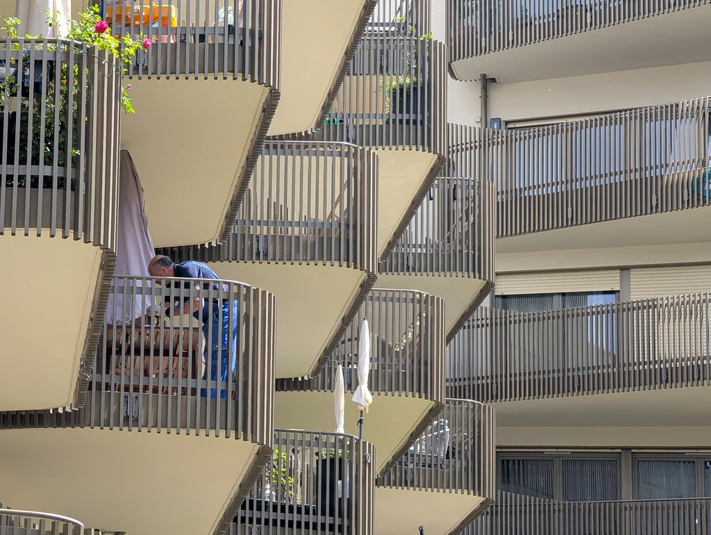 Młodych coraz częściej nie stać na zakup mieszkania, a wynajem staje się coraz droższy Balkony nowoczesnego bloku mieszkalnego z charakterystycznymi balustradami ułożonymi w geometryczny wzór, osoba ustawiająca meble na jednym z balkonów.
