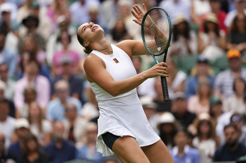 Aryna Sabalenka podczas meczu z Marie Bouzkovą na Wimbledonie, 02.07.2025 r. Zawodniczka grająca w tenisa w białym stroju podczas meczu, skoncentrowana na odbiciu piłki, tłum kibiców w tle
