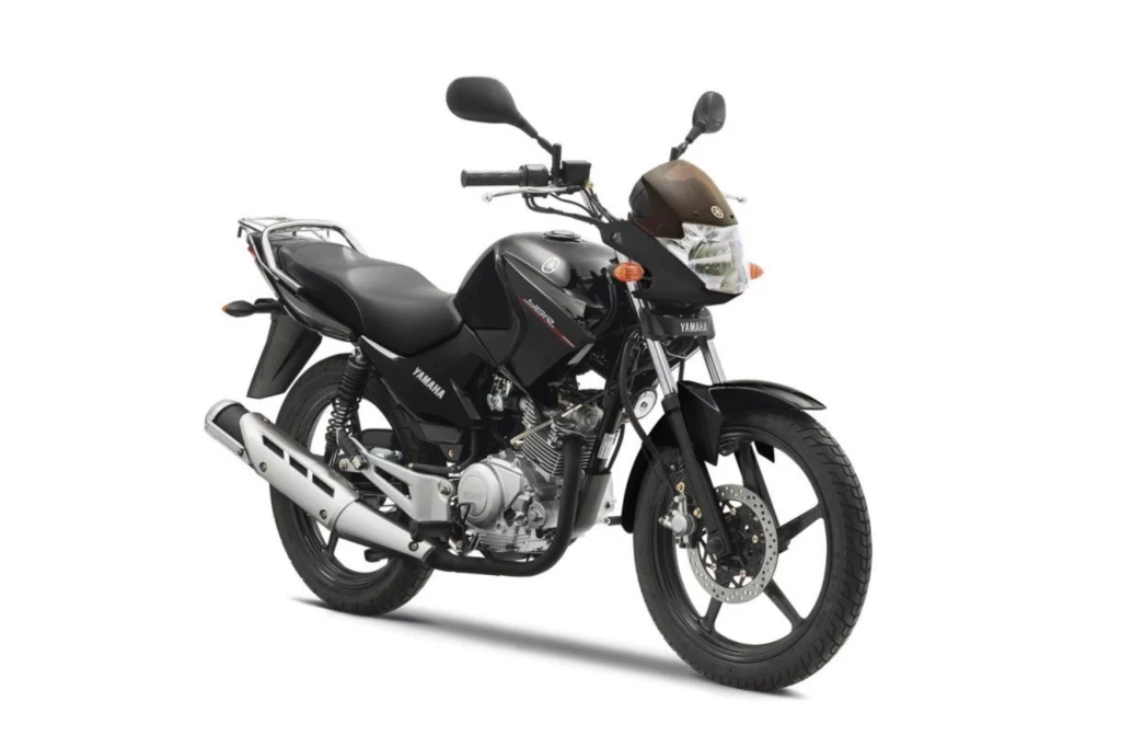 Yamaha YBR 125 podbiła świat za sprawą prostej konstrukcji, pancerności i niskiej ceny. Czarny motocykl marki Yamaha, model YBR125, z widocznymi detalami takimi jak srebrny tłumik, lusterka boczne, reflektor przedni i osłona na przednim kole na białym tle.