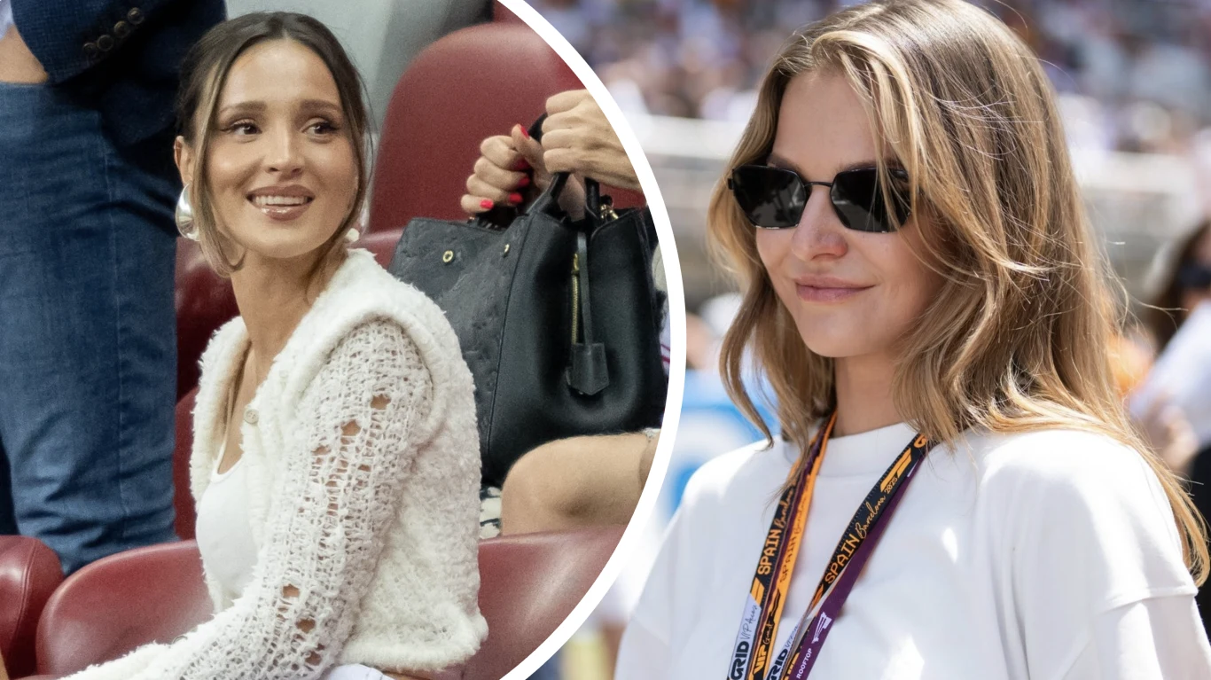 Marina Łuczenko-Szczęsna, Anna Lewandowska Dwie kobiety w casualowych stylizacjach, jedna z szerokim uśmiechem siedzi na stadionowych fotelach, druga w ciemnych okularach i z identyfikatorem na szyi, prawdopodobnie podczas wydarzenia sportowego.