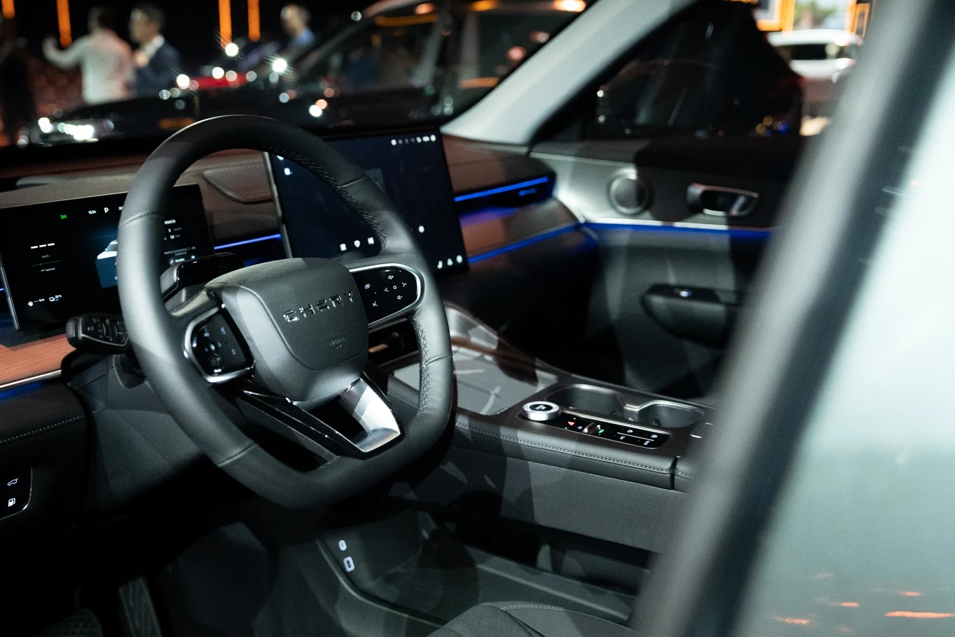 Luksusowe i nowoczesne wnętrze samochodu z dużym ekranem dotykowym, podświetleniem LED na desce rozdzielczej, wielofunkcyjną kierownicą oraz eleganckimi materiałami wykończenia.