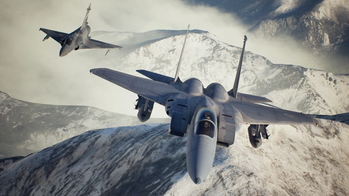 Ace Combat 7 Dwa myśliwce wojskowe lecą nad ośnieżonymi szczytami górskimi, silnie podkreślając dynamikę i potęgę maszyn powietrznych, na drugim planie widoczne krajobrazy górskie z mgłą w dolinach.