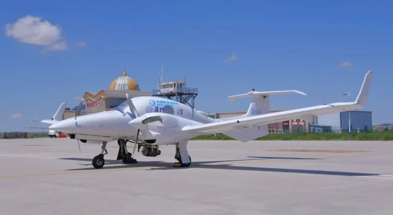 Chiński silnik turboodrzutowy z drukarki 3D pomyślnie przetestowany Nowoczesny biały samolot z dwoma silnikami na pasie startowym lotniska, w tle budynki lotniskowe oraz wieża kontroli lotów pod błękitnym niebem z kilkoma chmurami.