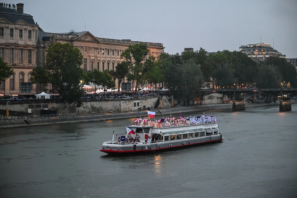W 1923 roku, z powodu zanieczyszczeń i ruchu rzecznego zakazano kąpieli w rzece Statek wycieczkowy płynący po szerokiej rzece, na pokładzie pasażerowie z flagami, w tle zabytkowe budynki i drzewa oraz wieczorne oświetlenie miasta.