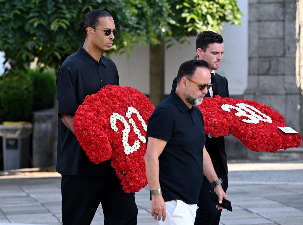 Virgil van Dijk i Andrew Robertson na pogrzebie Diogo Joty i Andre Silvy Trzech mężczyzn ubranych na czarno niesie kompozycje kwiatowe w kształcie koszulek z numerami 20 i 30 wykonane z czerwonych kwiatów, które symbolizują hołd lub pamięć.