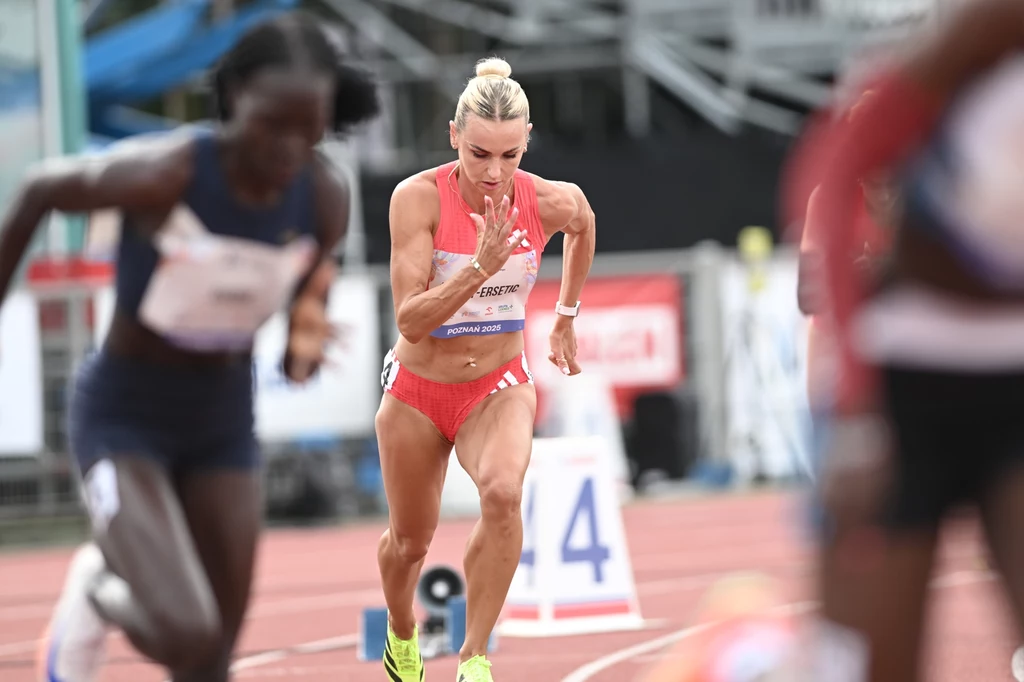 Justyna Święty-Ersetic w Poznaniu Zawodniczki rozpoczynają bieg na bieżni lekkoatletycznej, w centrum dynamiczna sylwetka sportsmenki w czerwonym stroju, skoncentrowana na starcie wyścigu.