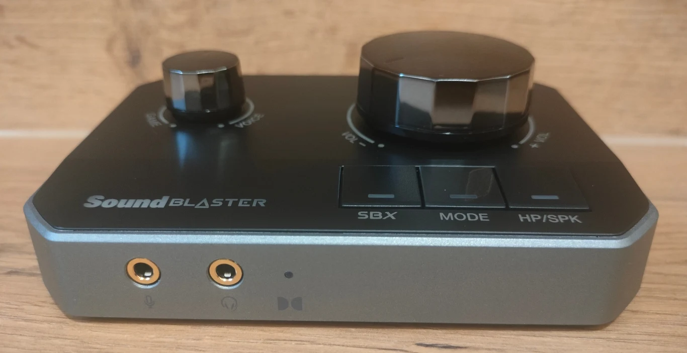 Sound Blaster G8 Zewnętrzna karta dźwiękowa Sound Blaster z dwoma dużymi pokrętłami do regulacji oraz trzema przyciskami funkcyjnymi SBX, MODE i HP/SPK, na przednim panelu znajdują się dwa gniazda jack.