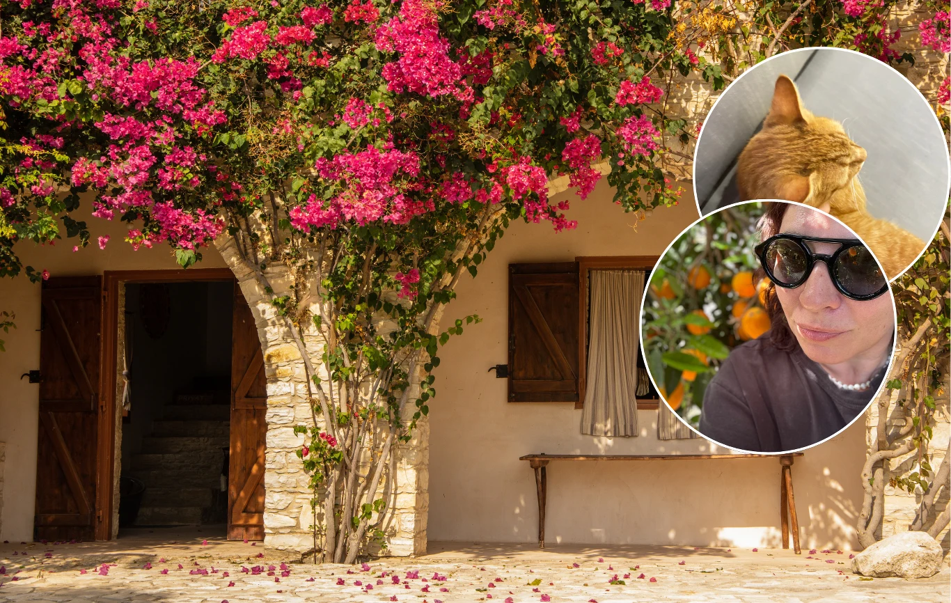 Tydzień na Cyprze. Niespodziewanie najlepiej odpoczęłam na zorganizowanej wycieczce Stary kamienny budynek z drewnianymi okiennicami i drzwiami, porośnięty obficie kwitnącą roślinnością o różowych kwiatach, w prawym górnym rogu dwa okrągłe wycinki prezentujące kota i kobietę w okularach przeciwsłonecznych, tło z owocującym krzewem.