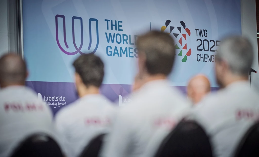 Grupa osób siedzących tyłem z widocznym tłem promującym The World Games 2025 w Chengdu, logotypy wydarzenia oraz napis województwo lubelskie, osoby ubrane w białe koszulki.