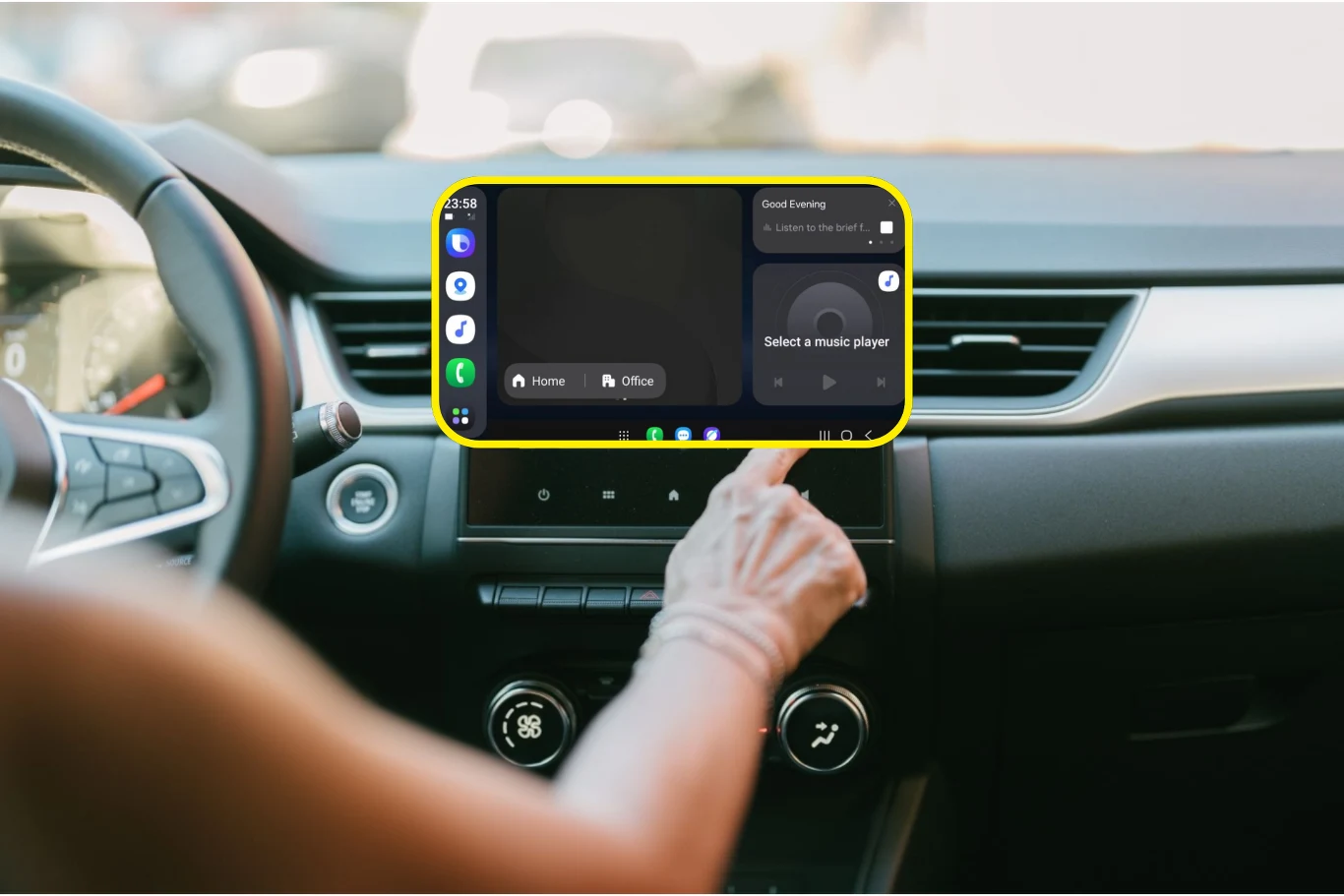 Auto DaX to konkurencja dla Android Auto i Apple CarPlay. / Fot. Galaxy Techie - X Kokpit samochodu z widocznym panelem dotykowym na konsoli centralnej, na którym wyświetlany jest interfejs systemu multimedialnego. Ręka osoby sięga do ekranu, wybierając opcję nawigacji. W tle niewyraźne elementy wnętrza auta.