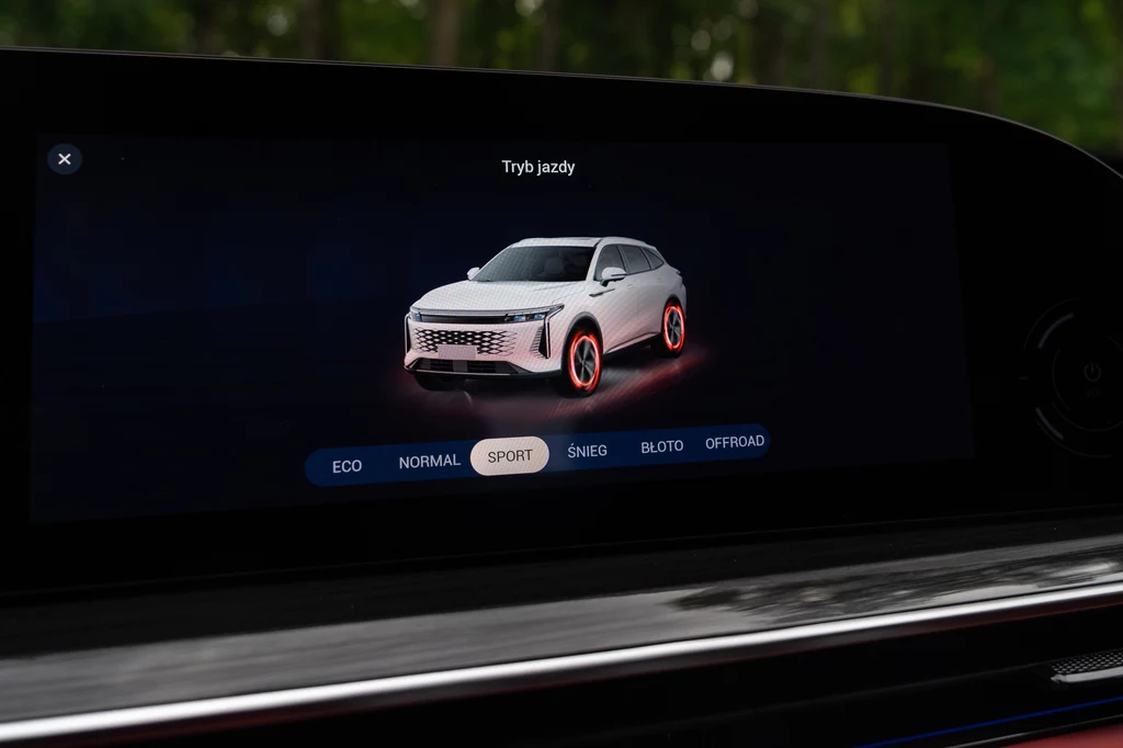 Omoda 9 ma świetne osiągi, ale nawet w trybie Sport trudno tu o sportowe emocje Ekran systemu multimedialnego samochodu z wirtualnym obrazem SUV-a i zaznaczoną opcją trybu jazdy SPORT, menu wyboru dostępnych trybów znajduje się na dole ekranu.