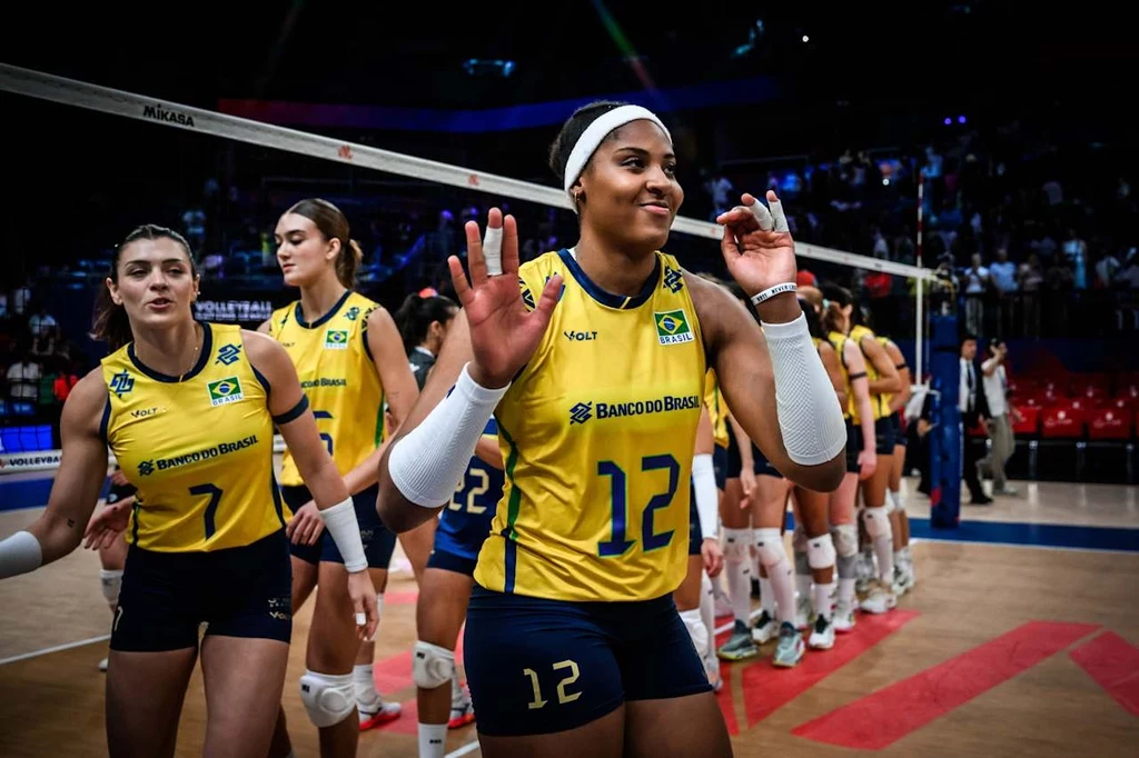 Ana Cristina w trakcie turnieju Ligi Narodów w Japonii już nie zagra. Opuści mecz Polska - Brazylia Zespół siatkarek w żółto-niebieskich strojach z numerami i logotypami Brazylii świętuje na hali sportowej, zawodniczki uśmiechnięte, wykonują gesty dłoni, w tle trybuny oraz siatka.