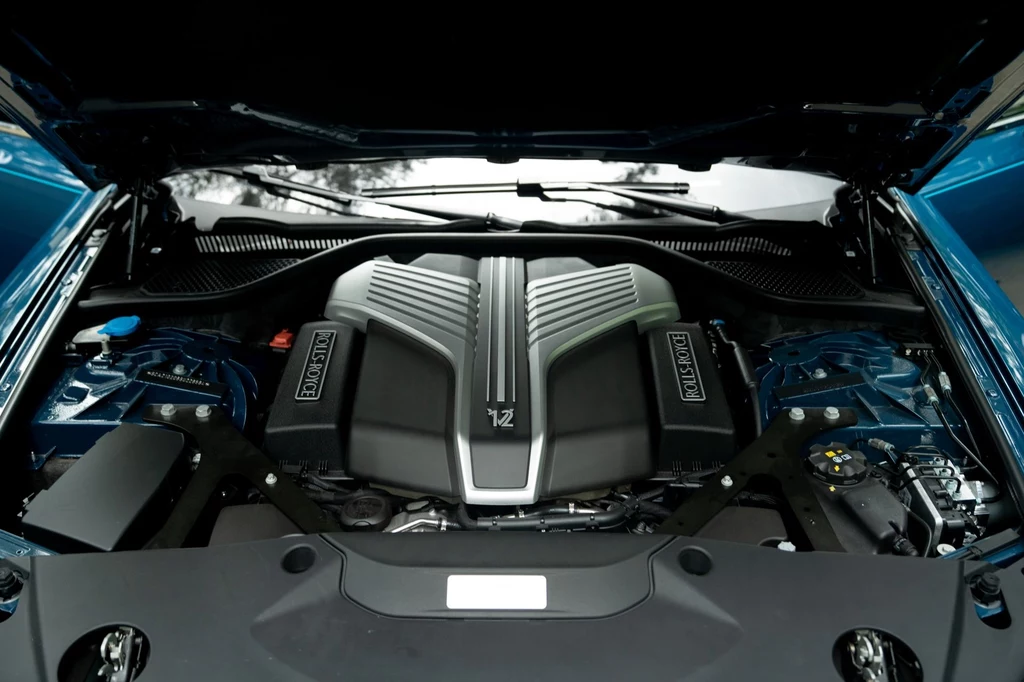 Rolls-Royce Ghost jest wyposażony w silnik V12 o pojemności 6,75 litra. Generuje 571 KM i 850 Nm. Silnik samochodowy umieszczony w komorze silnika, z widocznymi oznaczeniami producenta oraz elementami mechanicznymi, wszystko utrzymane w czystości i dobrze oświetlone.