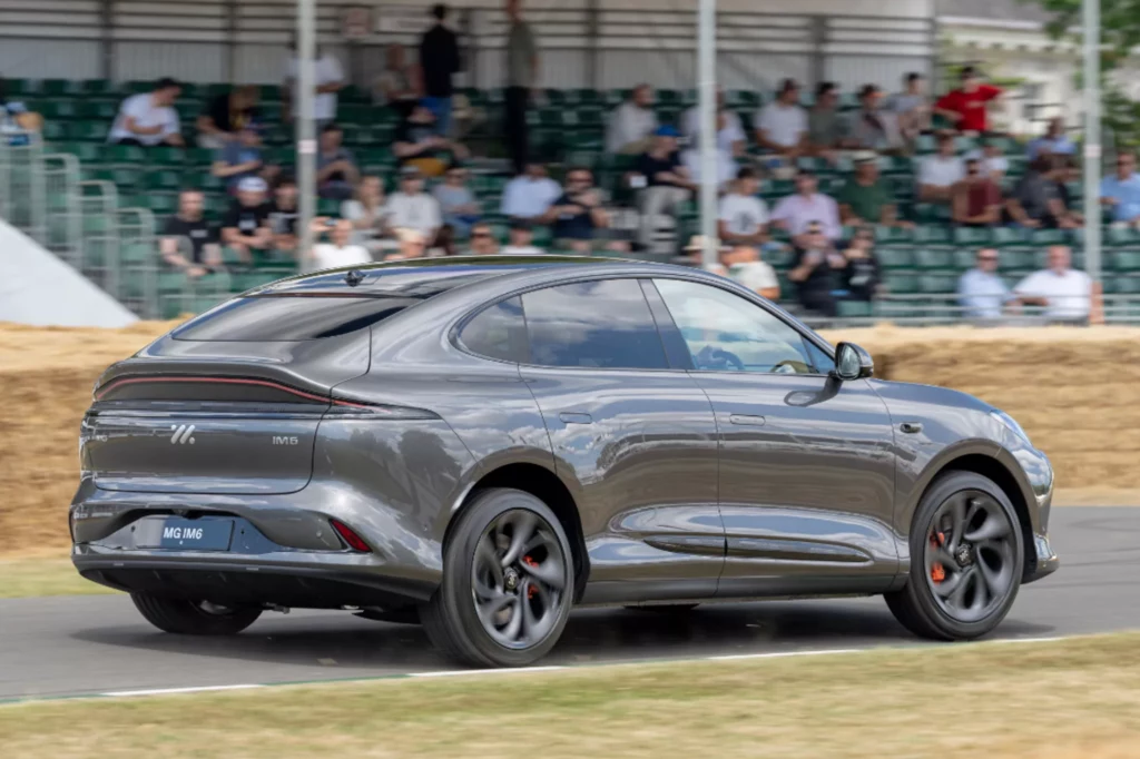 SUV IM6 w wersji Performance startuje do setki w 3,5 sekundy. Srebrnoszary samochód elektryczny w dynamicznym ruchu na torze, w tle widoczna publiczność siedząca na trybunach