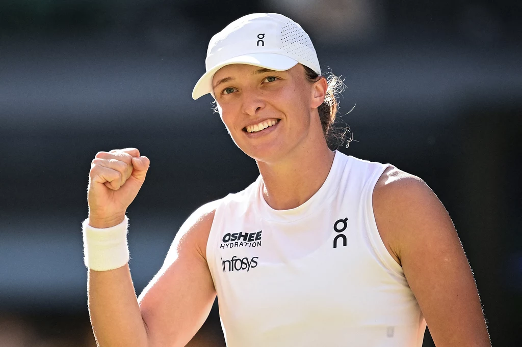 Iga Świątek rywalizowała z Amandą Anisimovą o tytuł na Wimbledonie Tenisistka w białym stroju sportowym z czapką, uśmiechnięta, zaciśnięta pięść unoszona w geście triumfu, wyraźnie na korcie tenisowym.