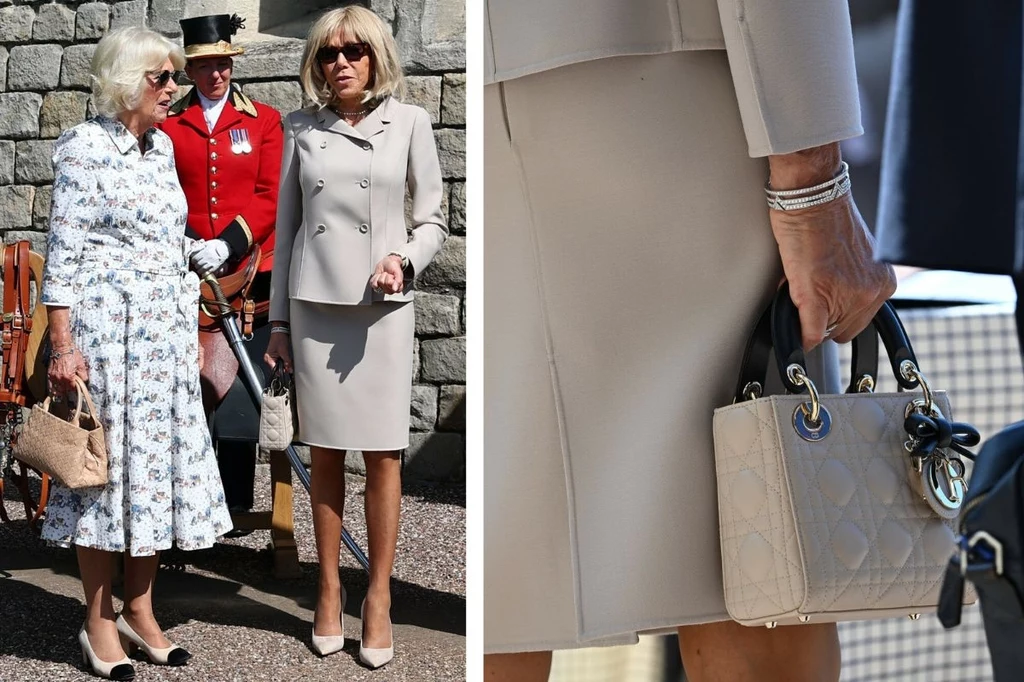 Brigitte Macron i królowa Kamila Dwie elegancko ubrane kobiety prowadzą rozmowę na tle kamiennego muru, jedna z nich trzyma beżową torebkę, w tle widoczny mężczyzna w czerwonym mundurze; po prawej stronie detal stroju i torebki.