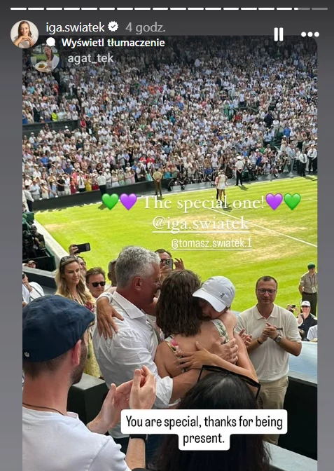Agata i Iga Świątek Grupa ludzi stojąca w tłumie przy korcie tenisowym, gdzie trwa ważny mecz. Na pierwszym planie wzruszający moment przytulenia, wokół dopingujący kibice, na tle pełnych trybun i zielonego kortu.
