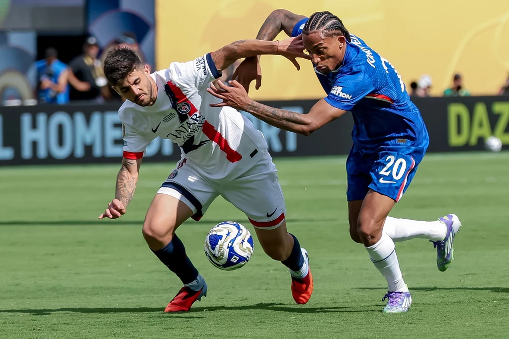 Joao Pedro (z prawej) w półfinale zdobył dwie bramki na wagę awansu. W finale dołożył kolejne trafienie Dwóch piłkarzy walczy o piłkę podczas dynamicznej akcji na boisku, jeden ubrany w biały strój z czerwonymi i czarnymi akcentami, drugi w niebieskim stroju, z intensywną interakcją fizyczną między zawodnikami.
