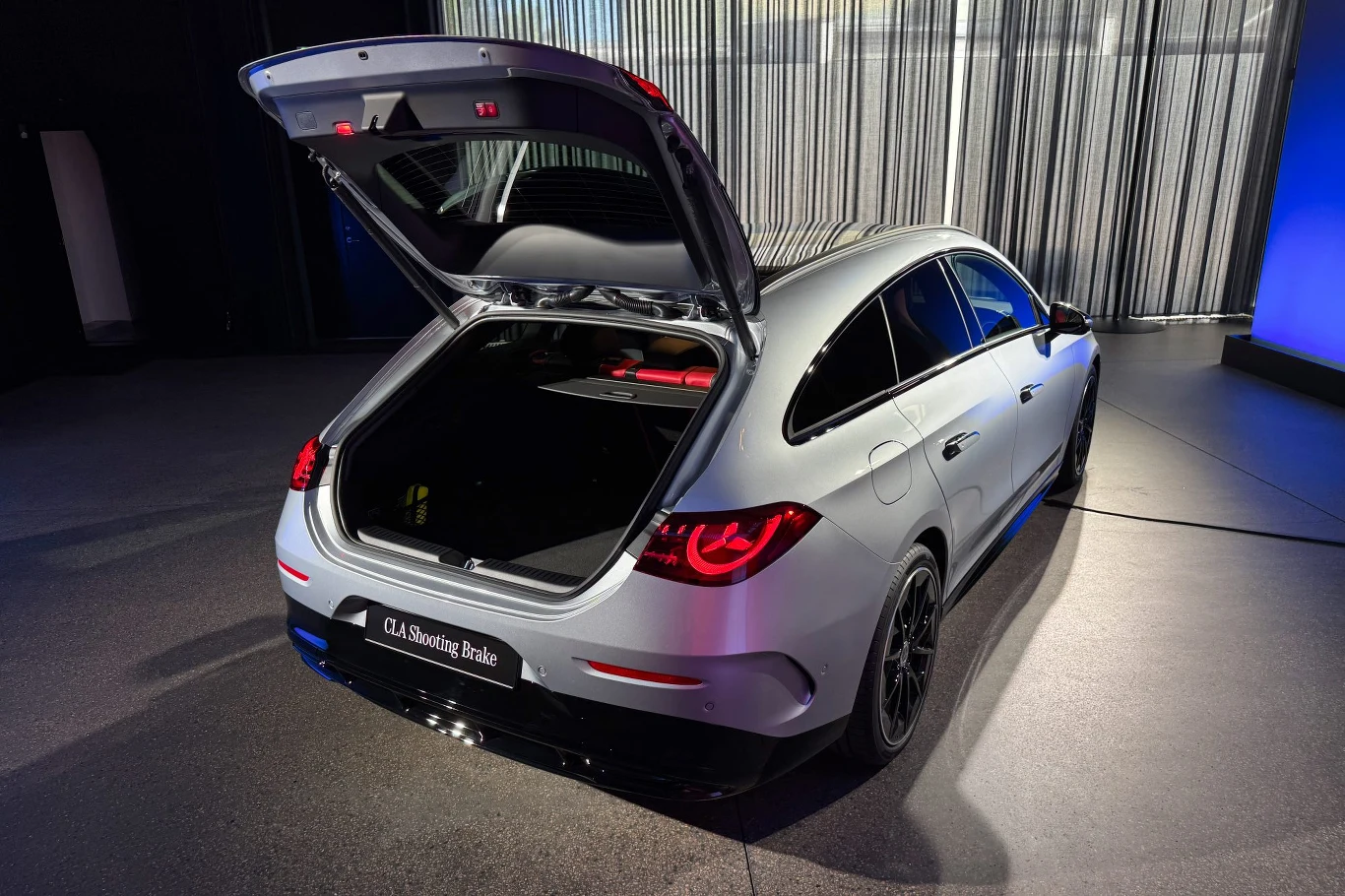 W porównaniu z modelem poprzedniej generacji, bagażnik zmniejszył się o 30 litrów. Za to dodatkowo pojawił się 101-litrowy bagażnik z przodu auta Srebrny samochód typu kombi z otwartą klapą bagażnika, ustawiony w nowoczesnym, dobrze oświetlonym wnętrzu. Wnętrze bagażnika jest widoczne, a elegancka sylwetka auta podkreślona refleksami światła.