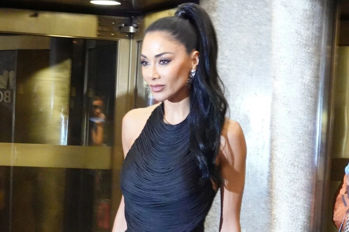 Nicole Scherzinger nie wygląda na 47 lat Kobieta w eleganckiej, czarnej sukni z długimi, ciemnymi włosami spiętymi w wysoki kucyk, stojąca w dobrze oświetlonym miejscu obok metalowego filaru.