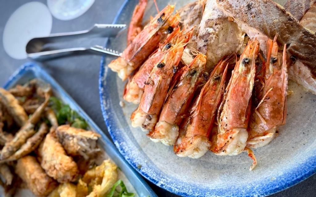 Poziom restauracji nie odbiega od tych znanych z północnych rejonów basenu Morza Śródziemnego Talerz z grillowanymi krewetkami ułożonymi na kromkach świeżego chleba, obok widoczne są smażone ryby i owoce morza podane na osobnym półmisku.