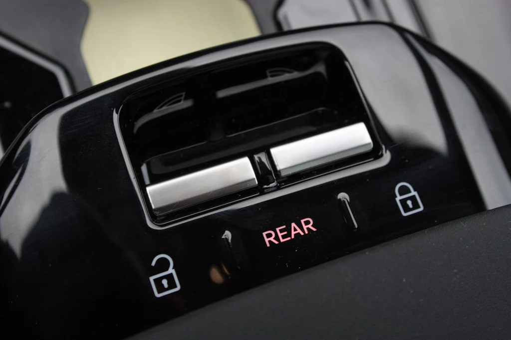 Nieliczne fizyczki przyciski w Volvo EX30. Dwa do sterowania czterema szybami Panel sterowania szybami samochodowymi z przyciskiem blokowania i podświetlonym napisem REAR, wskazującym na możliwość sterowania tylnymi szybami pojazdu.