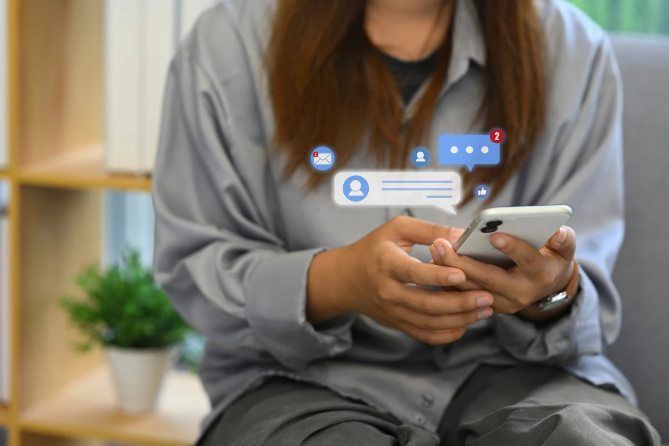 Co to jest czat RCS i jak go wyłączyć? Osoba trzyma smartfona w dłoniach, na ekranie pojawiają się ikony powiadomień dotyczące wiadomości, komentarzy i polubień, co sugeruje aktywność na portalach społecznościowych.