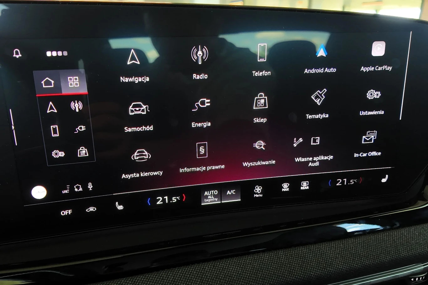 Do obsługi multimediów służy 14,5-calowy ekran. Obsługujemy z jego poziomu większość funkcji w aucie. Ekran dotykowy systemu multimedialnego samochodu z wyraźnie widocznymi ikonami, takimi jak nawigacja, radio, telefon, informacje o pojeździe oraz klimatyzacja, wszystkie opcje są czytelnie oznaczone i rozmieszczone na czarnym tle.