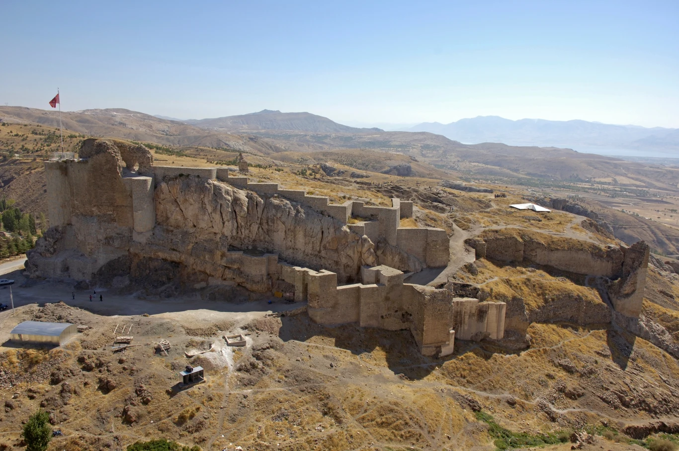 Prowincja Elazığ w Turcji słynie z ciekawych odkryć archeologicznych. Teraz doszło do kolejnego unikatowego odkrycia. Zdj. ilustracyjne. starożytna twierdza zbudowana na skalistym wzgórzu, otoczona murami i basztami, z rozległym widokiem na suchy, pagórkowaty krajobraz i odległe góry, na szczycie powiewa flaga